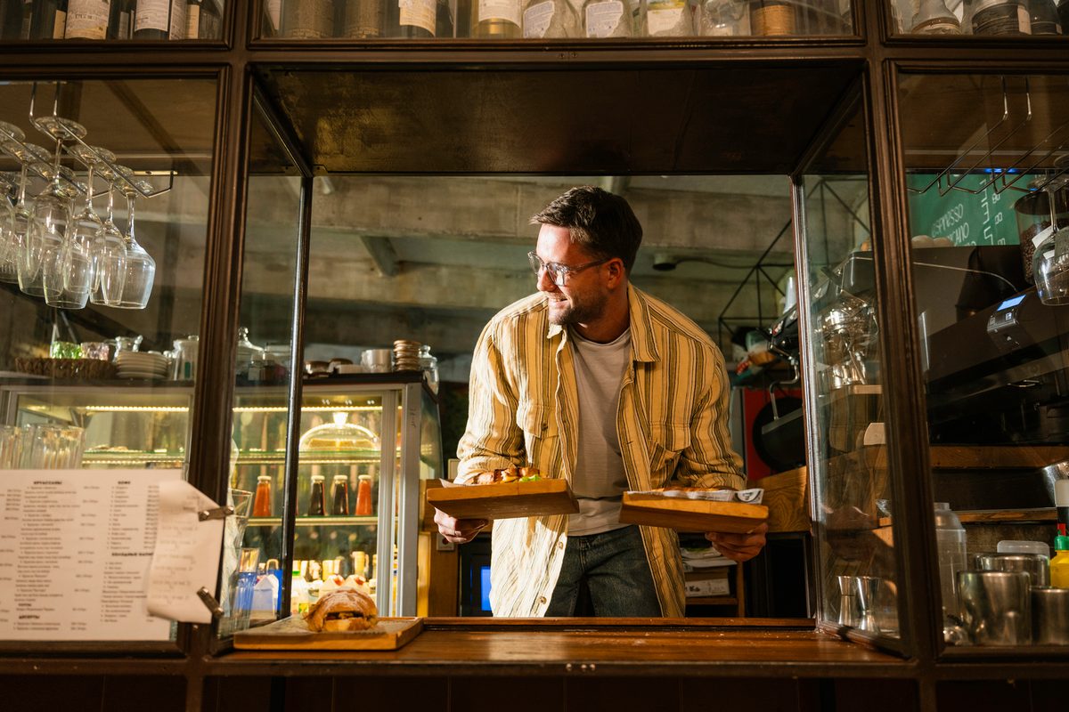 A small-business owner behind the counter of an Australian café